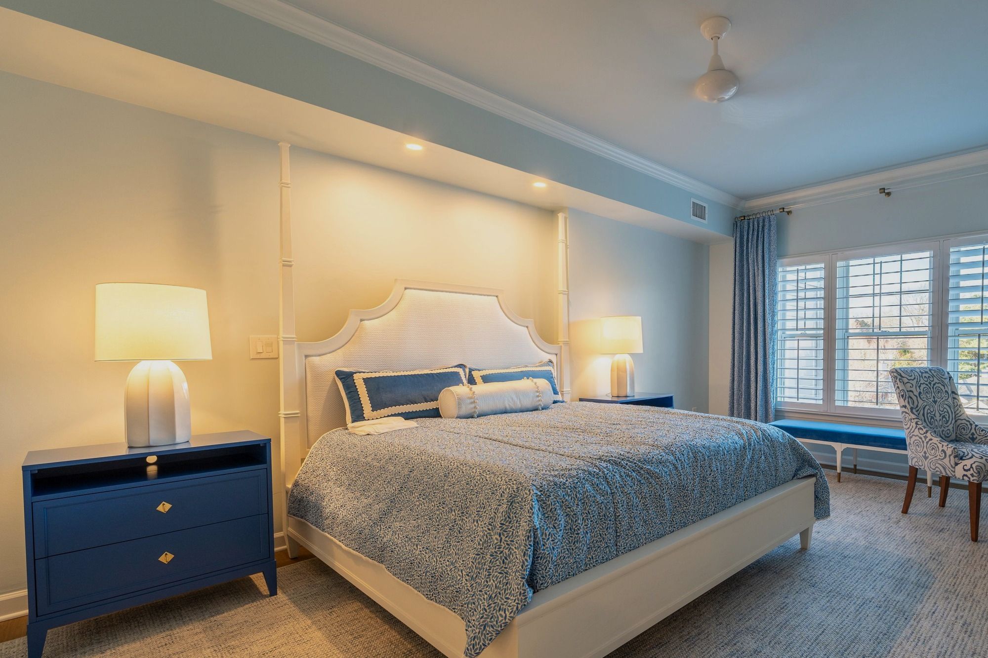 Classic bedroom with shuttered windows and a made bed
