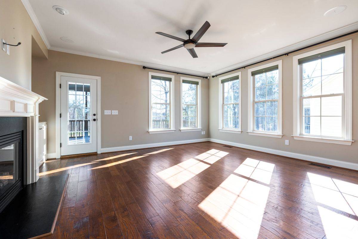 Empty living room with sunlight across hardwood floors