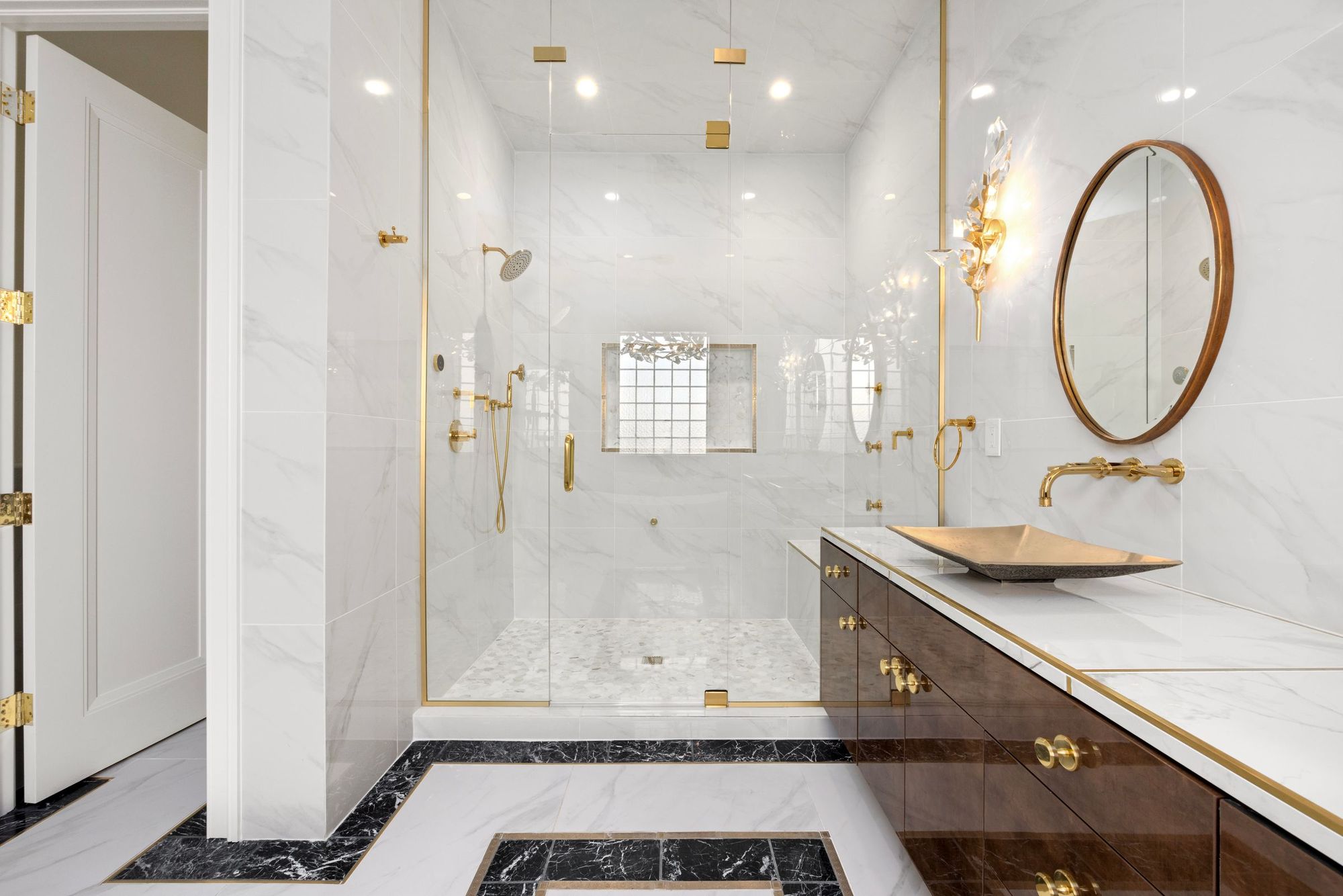 Marble bath with brass fixtures and a walnut vanity