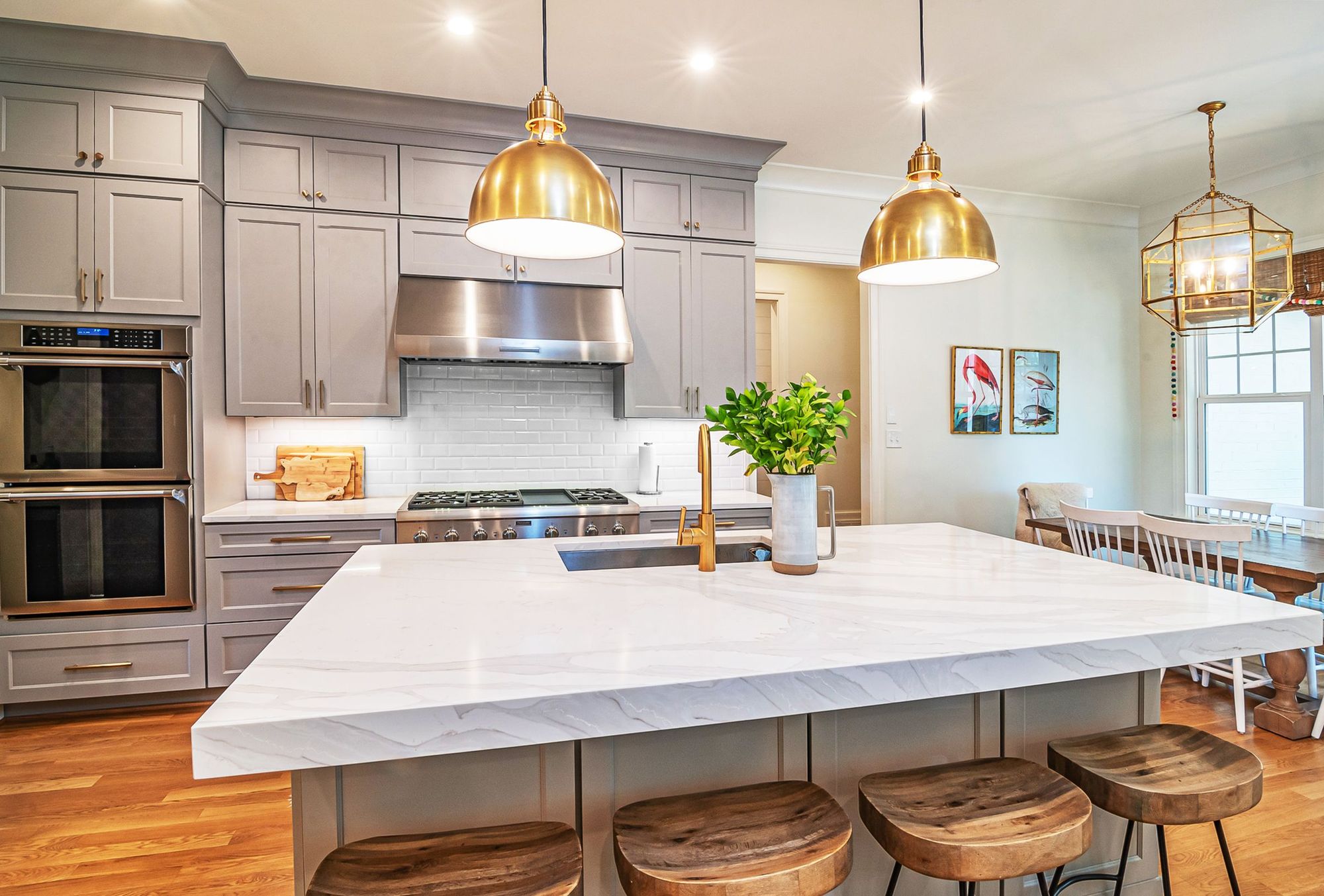 Marble island kitchen with brass pendant lights